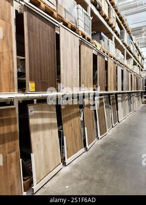Kyiv, Ukraine - January 03, 2025: Various types of wood laminate flooring panels displayed in orderly shelves at a hardware store, illustrating availa Stock Photo