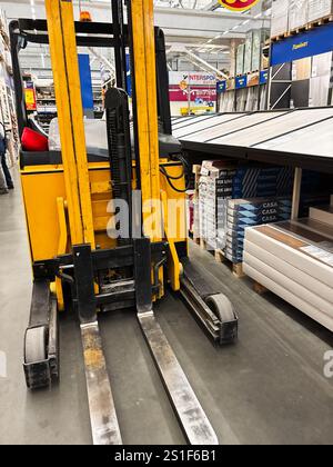 Kyiv, Ukraine - January 03, 2025: Industrial forklift operates in a warehouse environment with organized shelves of materials and products. Stock Photo
