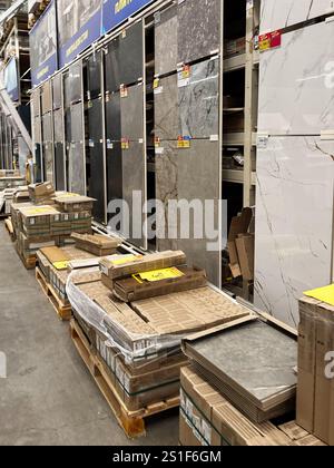 Kyiv, Ukraine - January 03, 2025: Rows of wall and floor tiles showcased in a hardware store with multiple styles. Display racks and palletized boxes Stock Photo