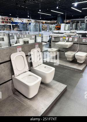 Kyiv, Ukraine - January 03, 2025: Brightly lit showroom featuring various toilets and bathroom sinks on display for sale. A professional retail enviro Stock Photo