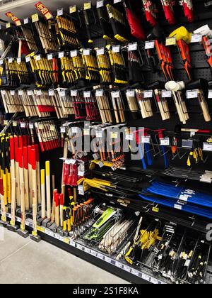 Kyiv, Ukraine - January 03, 2025: A well-organized selection of various tools, including hammers, axes, and garden tools, neatly displayed on shelves Stock Photo