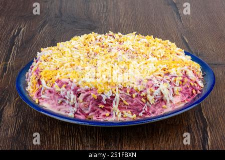 Traditional Russian multi-layer salad Herring under a fur coat made from chopped herring, beets, potatoes, carrots and eggs. Home cooking. Stock Photo