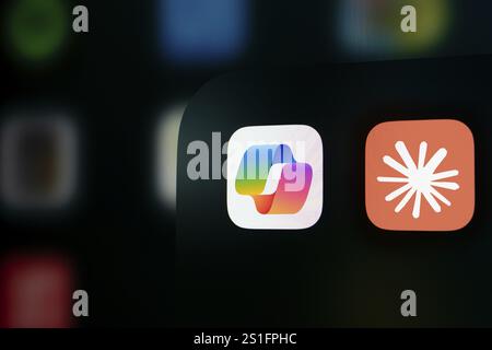 A close up of an iPhone screen displaying the Microsoft Copilot and Claude AI app icon. Stock Photo