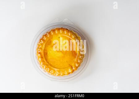 A freshly baked round butter bun enclosed in clear plastic packaging, displayed on a white background. perfect for bakery promotions, and food adverti Stock Photo