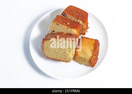 Top view of four pieces of freshly baked sponge cake arranged on a white plate. perfect for desserts or tea time snacks. Stock Photo