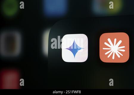 A close up of an iPhone screen displaying the Google Gemini and Claude AI app icon. Stock Photo