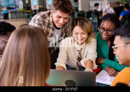 Multiracial young group of language students looking smiling at notebook sitting in academy Stock Photo