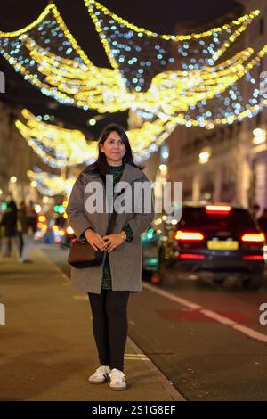 Asian Woman Entrepreneur Exploring Regent Street, London During the Festive Christmas Season Stock Photo