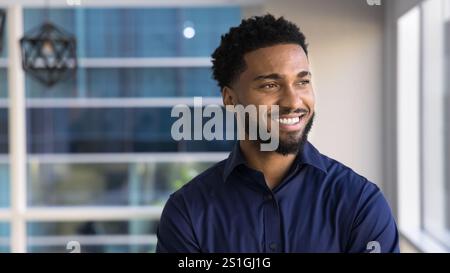 Happy dreamy African business leader man looking at window away Stock Photo