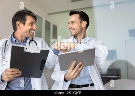 Two happy medical professional friends bumping fists Stock Photo