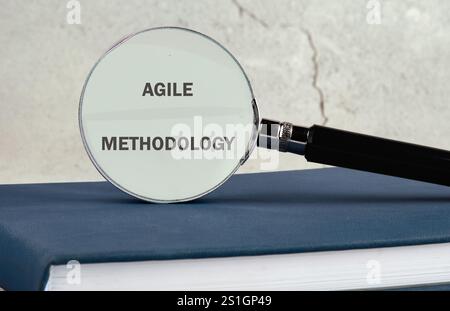 Fast changes concept. AGILE METHODOLOGY on the glass of a magnifying glass on a gray background. Stock Photo