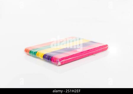 Colorful wooden ice cream or popsicle sticks pack inn a plastic wrapping isolated on white background Stock Photo