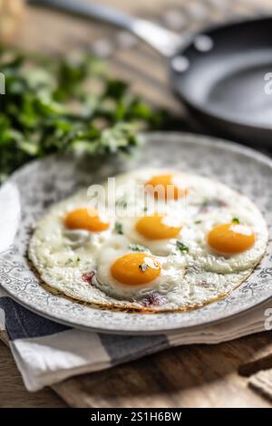 English breakfast on a plate. Ham and eggs sprinkled with parsley. Stock Photo