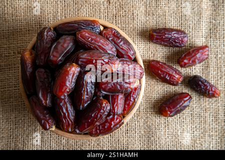 Dates fruit in a wooden bowl, top view Stock Photo