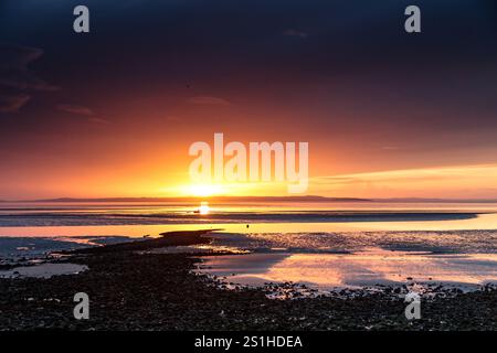 Vivid and dramatic sunset over Llandudno West Shore beach on the North Wales coast Stock Photo