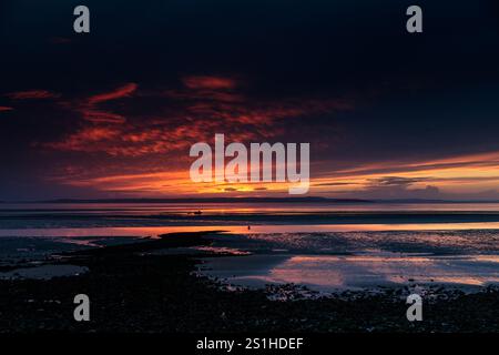 Vivid and dramatic sunset over Llandudno West Shore beach on the North Wales coast Stock Photo