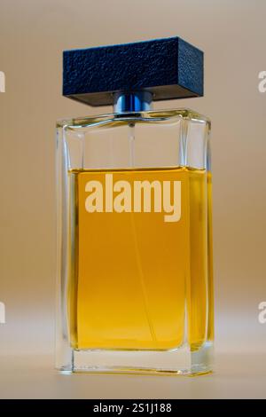 Perfume mockup bottle with a black textured cap and amber liquid inside, featuring an elegant and minimalist design. Perfect for luxury beauty product Stock Photo