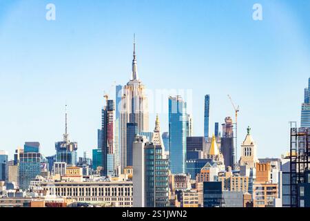 Panoramic view of the New York City skyline with iconic skyscrapers  empire state building and clear blue sky in the background Stock Photo