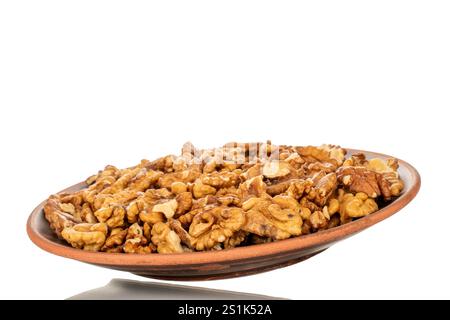 Shelled walnuts on a clay plate, close-up, isolated on a white background. Stock Photo