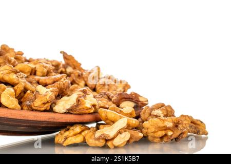 Shelled walnuts on a clay plate, close-up, isolated on a white background. Stock Photo