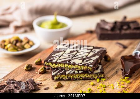 Homemade Dubai chocolate with white and dark chocolate, pistachio cream, kadayif and pistachios on wooden background Stock Photo