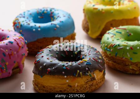 Colorful glazed donuts with sprinkles on white background Stock Photo