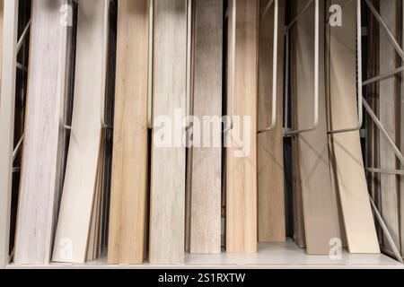 A close-up of various wooden laminate textures and colors displayed on racks in a home improvement store, showcasing modern flooring options for inter Stock Photo