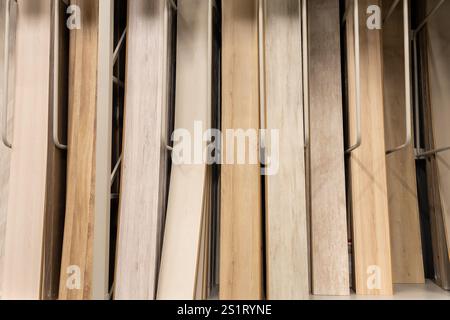 A close-up of various wooden laminate textures and colors displayed on racks in a home improvement store, showcasing modern flooring options for inter Stock Photo