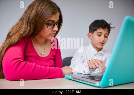 Girl and boy using laptop, focused on homeschooling or online education Stock Photo