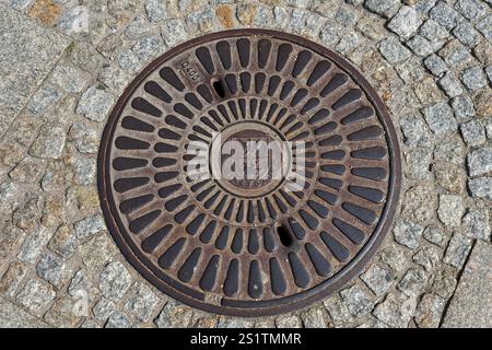 Round manhole cover with central pattern on paved surface, manhole cover, BiaNystok, Bialystock, Bjelostock, Podlaskie, Poland, Europe Stock Photo