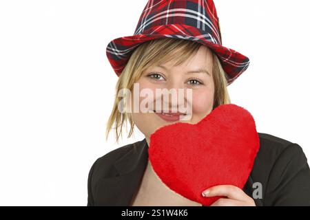 Young woman holding a fabric heart on a light background Stock Photo