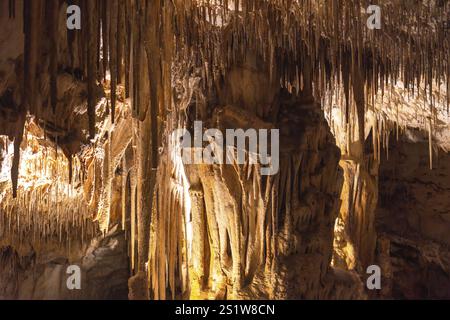 Warm colored stalactites and stalagmites creating evocative shapes inside the caves of drach in majorca, spain Stock Photo