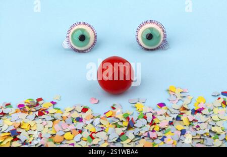 Red Nose with confetti over light blue background. Conceptual Photo to use for all funny celebration themes Stock Photo
