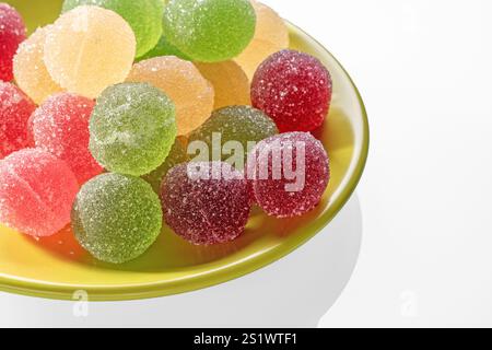 Saucer with multi-colored marmalade balls on a white background, space for text Stock Photo
