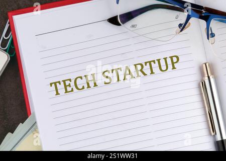 The concept of technology . The conceptual text of TECH STARTUP it is written in the business book in close-up, top view. Stock Photo