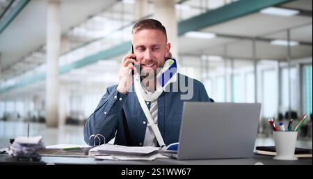 Broken Arm Injured Worker Compensation Coverage. Using Office Laptop Stock Photo