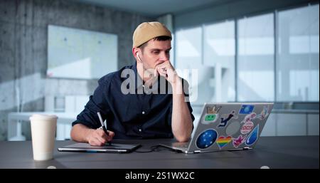 Tired Unhappy Graphics Designer Man Using Laptop Stock Photo