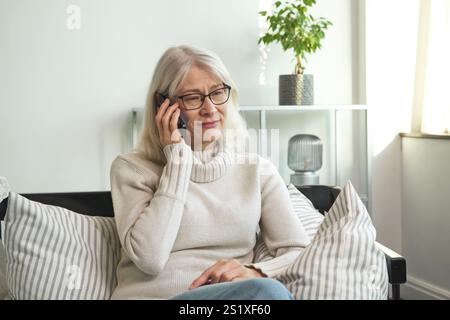 Senior woman having a phone conversation on her smartphone Stock Photo