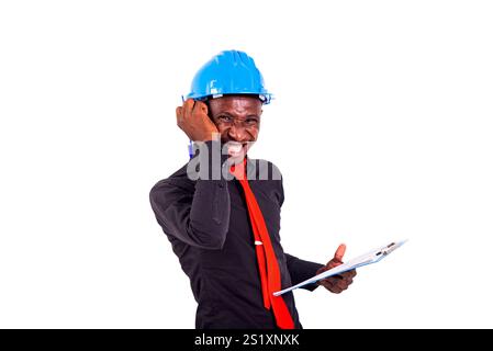 young man engineer wearing blue safety helmet and holding clipboard while smiling. Stock Photo