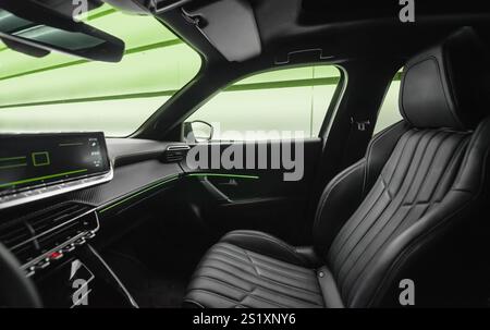 Front passenger seat in modern car. Car cockpit wide angle view from driver seat: center console with display, leather passenger seat and door. Stock Photo