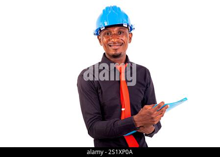 portrait of a young man engineer wearing a hard hat holding documents in his hands while smiling. Stock Photo