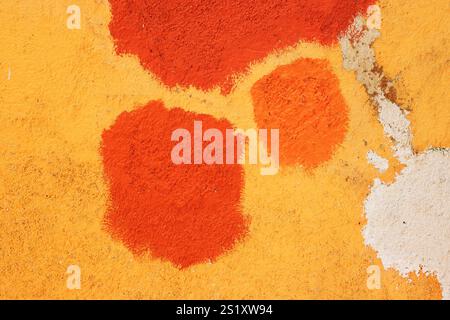Texture of old house concrete wall painted into deep Vibrant warm golden yellow color with orange spots and cracks on the surface. Decorative plaster. Stock Photo