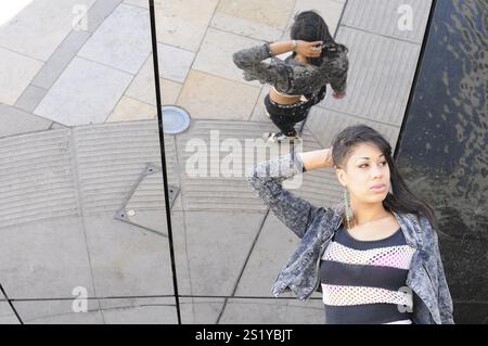 Young adult youthfully dressed mixed race black woman outside Stock Photo