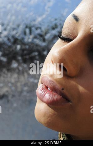 Close up portrait young adult mixed race black woman with her eyes closed. Stock Photo