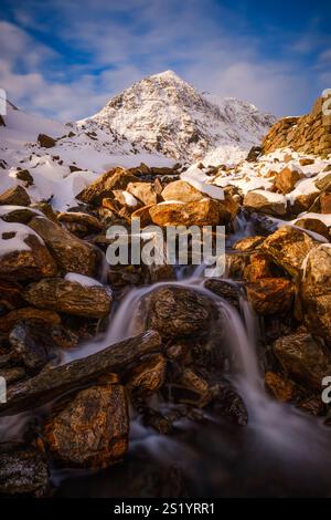 A winter view of Snowdon (Yr Wyddfa) from Afon Glaslyn, a stream tumbling down the hillside from the lake Glaslyn, Snowdonia (Eryri), North Wales Stock Photo