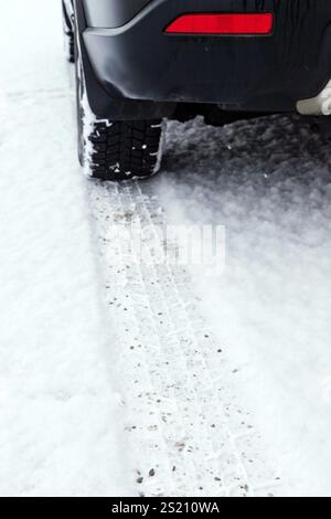Spuren von Winterreifen im Schnee auf der Fahrbahn einer Strasse, Traces of snow tires in the snow on the roadway of a street Austria Stock Photo