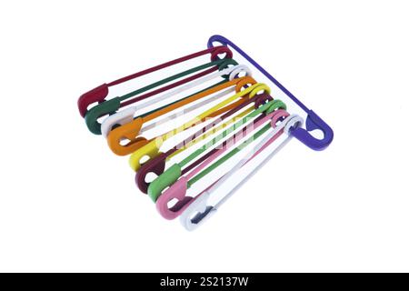 Many colourful safety pins lie on a white background Austria Stock Photo