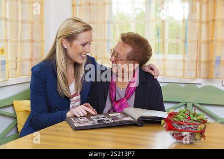 A grandson visits his grandmother Viewing the photo album. Austria Stock Photo