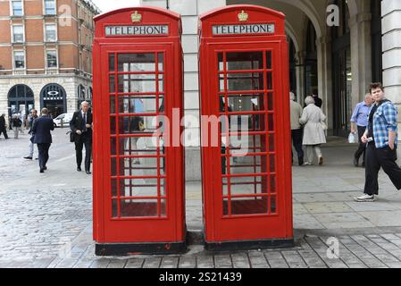 Telephone boxes, Covent Garden Market, The Market, West End, London, Two red telephone boxes stand in a busy street and attract attention, London, Lon Stock Photo