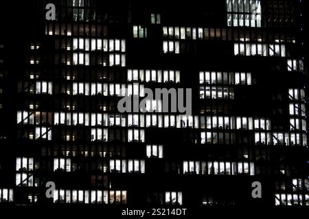 Many illuminated windows of an office building. Working at night. Austria Stock Photo